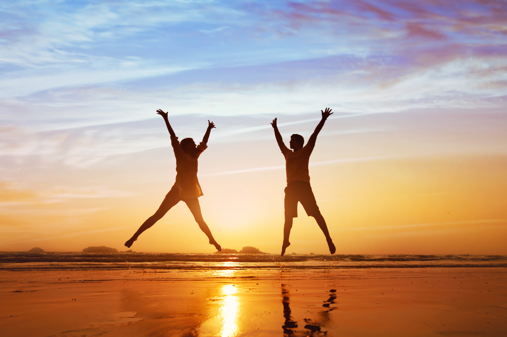 happy couple jumping on the beach at sunset, family summer holidays or honeymoon