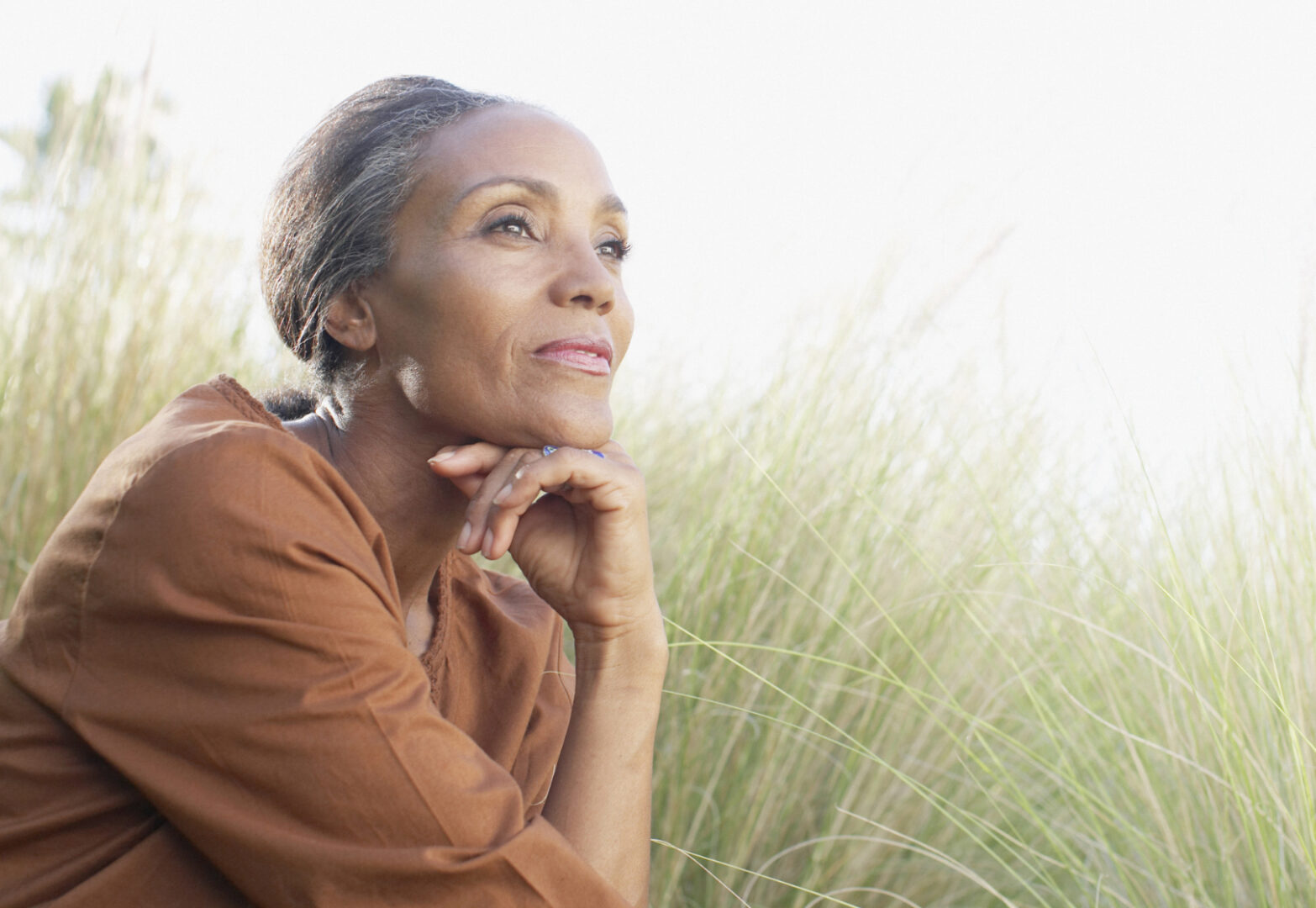 Serene woman sitting in sunny field